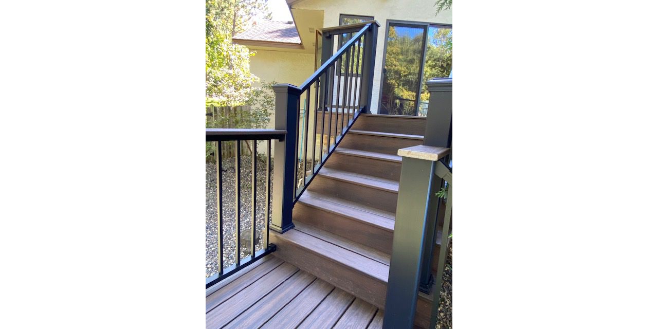 Trex/Transcend/Spiced Rum/Composite Decking with Trex/Signature/Aluminum Railing (black) between Trex Composite Post Sleeves and Trex/Transcend/Spiced Rum/Composite Decking for Cocktail Rail