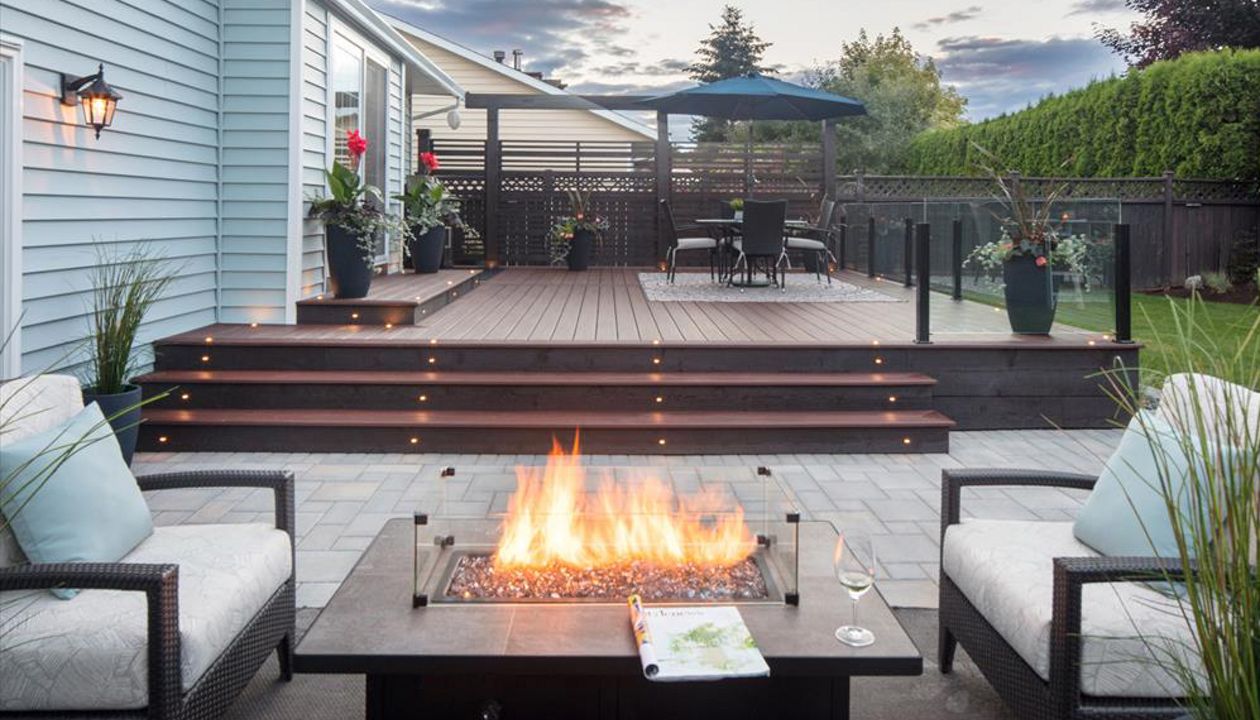 Trex Transcend Lava Rock with LED deck lighting, fire table and topless glass railings. Project location Pitt Meadows BC