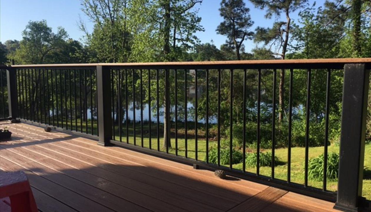 Trex Transcend Charcoal Black Rails with Tiki Torch cocktail rails allow this homeowner to see the wonderful pond and landscape