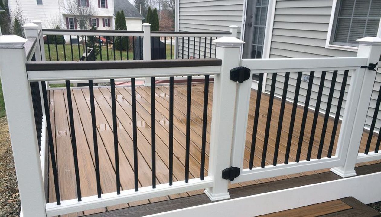 Trex transcend Havana gold main decking, transcend spiced rum picture frame border, Trex White PVC fascia, Trex select white rails with black metal balusters