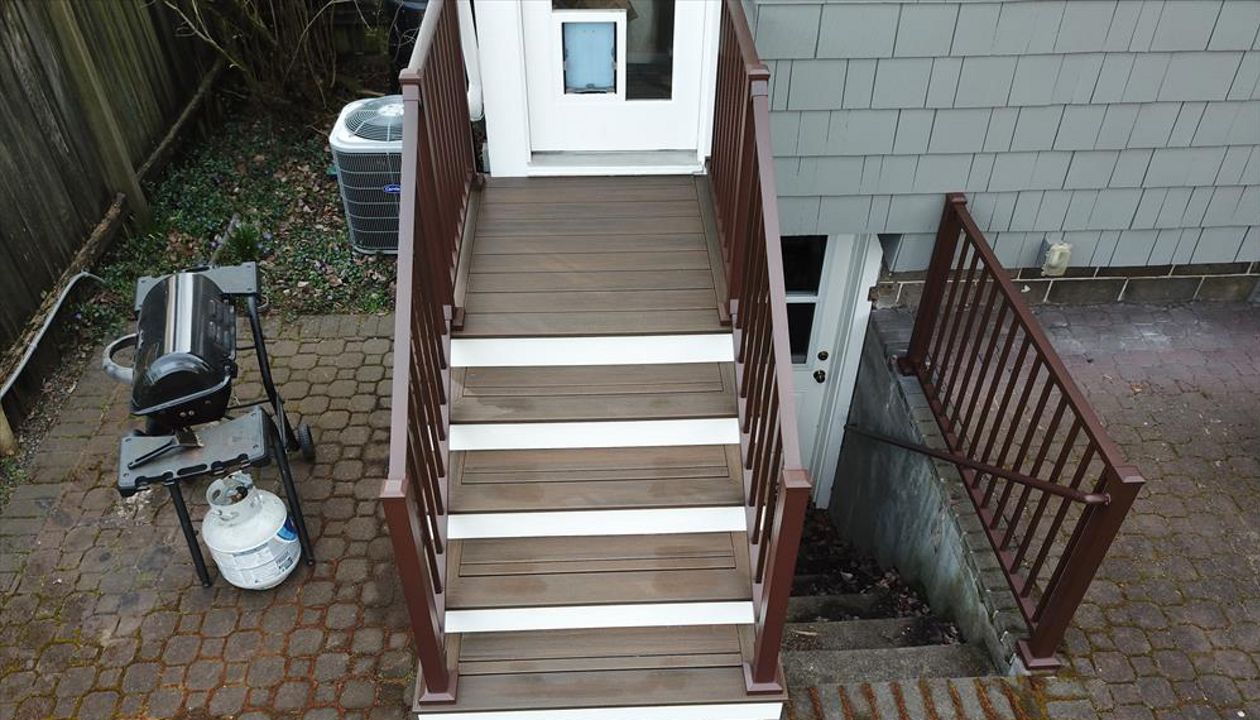 Trex Spiced Rum deck with white Trex Universal Fascia. The railing is Trex bronze signature railing and ADA railing.