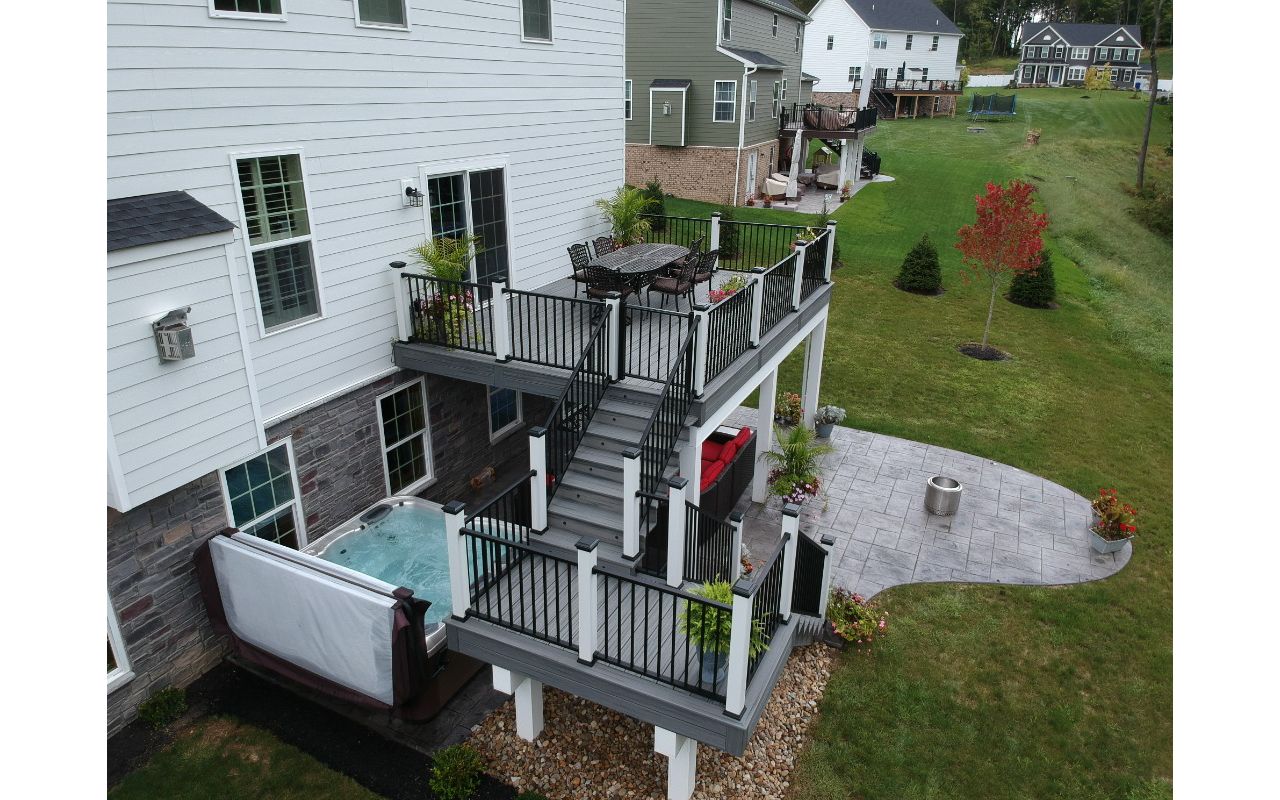 Island Mist decking with Signature railing over stamped concrete patio with hot tub