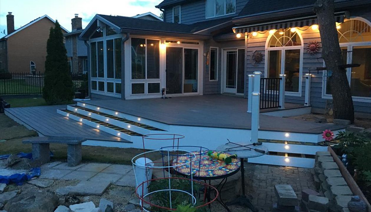 Transcend decking in Island Mist with a double picture frame and stair lighting. Signature Black handrail with white posts and lighted post caps.