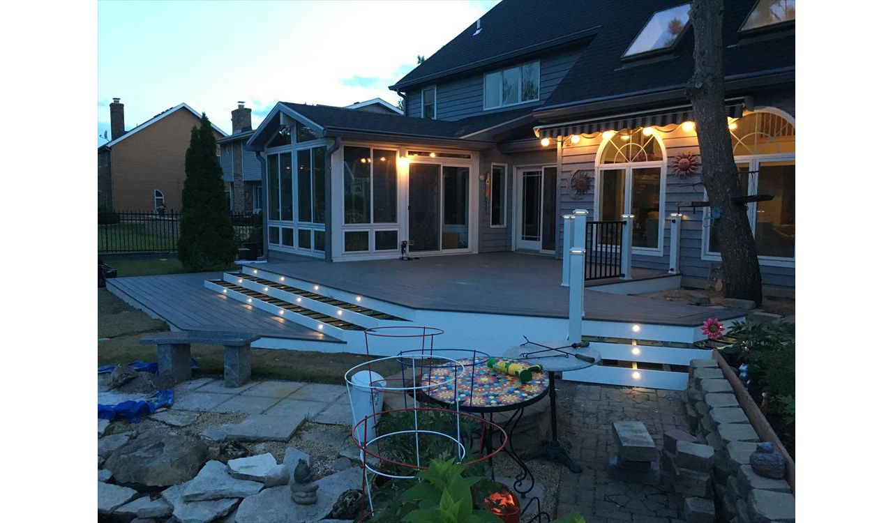 Transcend decking in Island Mist with a double picture frame and stair lighting. Signature Black handrail with white posts and lighted post caps.