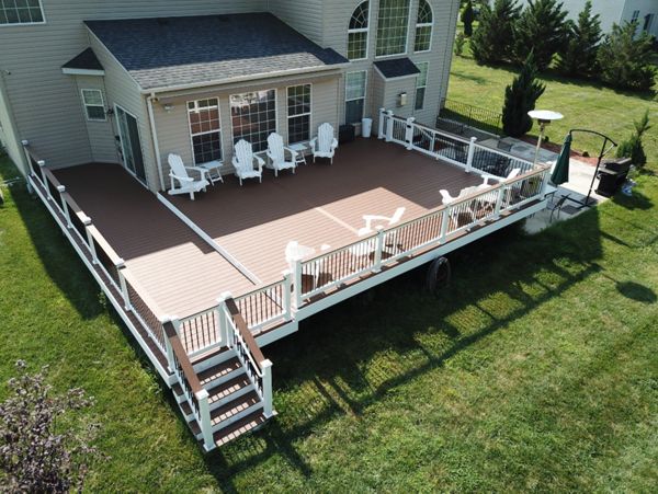 Trex Select Saddle Composite Deck with White Washington Vinyl Railing with round aluminum balusters and a matching drink rail