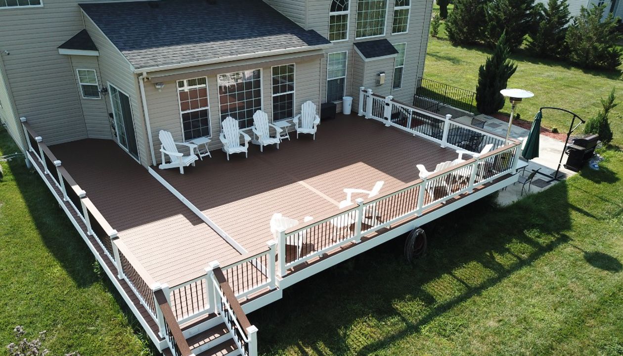 Trex Select Saddle Composite Deck with White Washington Vinyl Railing with round aluminum balusters and a matching drink rail