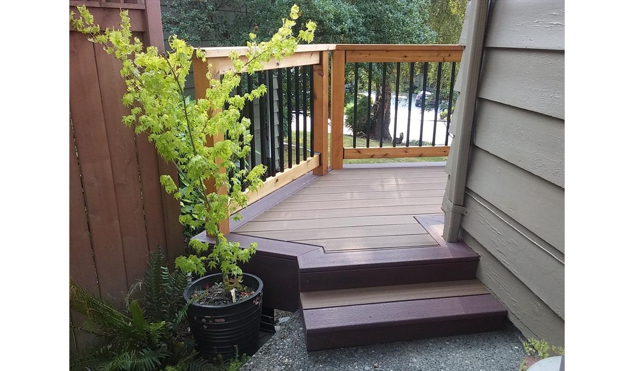Trex Contour Torino Brown with Moroccan Red border with stained tight knot cedar rails and black aluminum balusters.