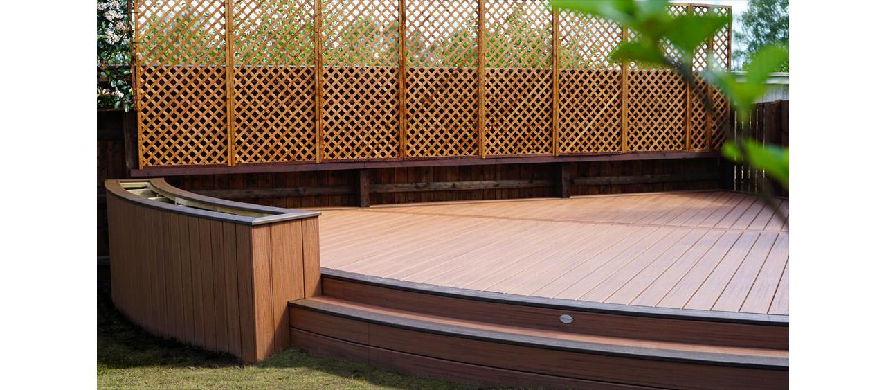 Tiki touch with a spiced rum boarder from the trex transcend tropical range,  specialist curved deck design for our customer in Corby Northampton