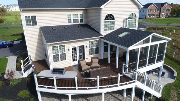 Screened in porch with decking in Trex Foggy Wharf with two Adirondack chairs looking out on the yard