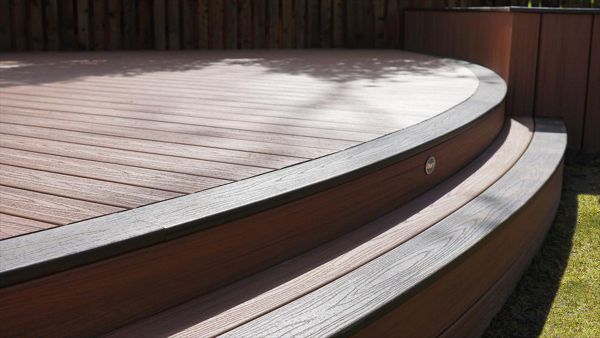 This was a absolute pleasure working on this deck in Weldon Cory Northamptonshire, what can you say, we were asked for curves and we didn’t disappoint, huge curved decking area with curved steps and curved planters, in trex tiki torch with lava rock edge.