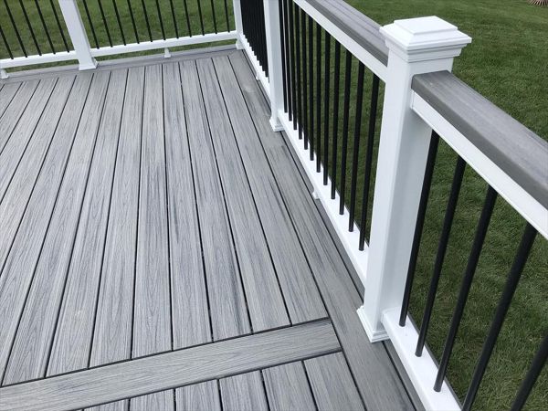Deck in New Hudson, MI., constructed out of Trex Transcend Tropical decking in Island Mist and complimented by Classic White Trex railing with black balusters and Classic White privacy wall.
