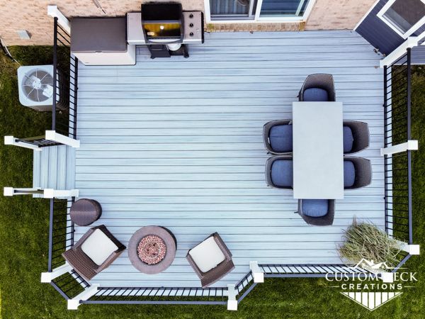 Trex Enhance Naturals Foggy Wharf decking with Trex Signature aluminum railing in black. White Trex composite post sleeves.