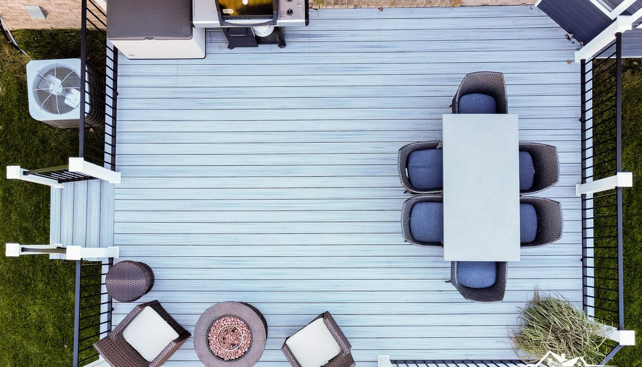 Trex Enhance Naturals Foggy Wharf decking with Trex Signature aluminum railing in black. White Trex composite post sleeves.