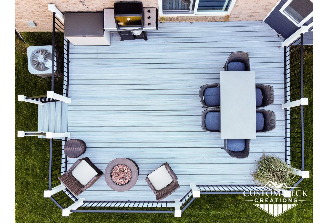Trex Enhance Naturals Foggy Wharf decking with Trex Signature aluminum railing in black. White Trex composite post sleeves.