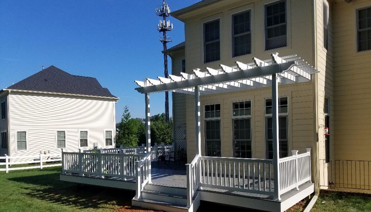 Trex Select Pebbly Grey decking with white pvc railings. This deck also features a PVC Sun Trellis