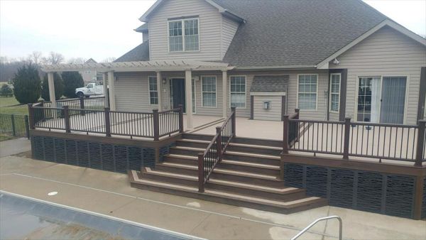custom deck with flared staircase, triple border, 3-tread wide bordered staircase, lighting, vinyl pergola, and decorative skirting