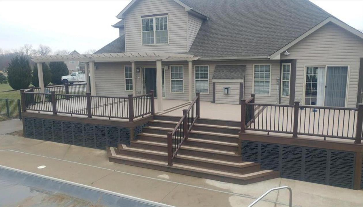 custom deck with flared staircase, triple border, 3-tread wide bordered staircase, lighting, vinyl pergola, and decorative skirting