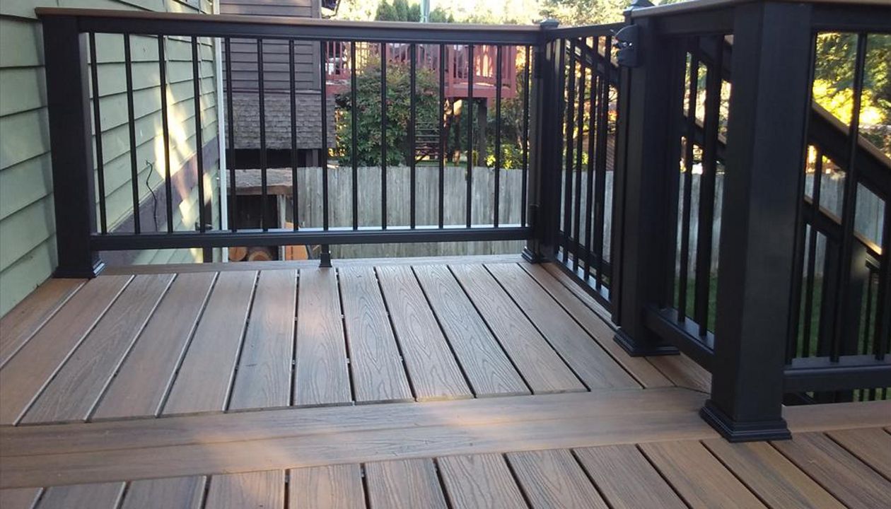 Trex Transcend Tropical Havana Gold decking and cocktail rail with Trex Transcend black composite rail with aluminum pickets.