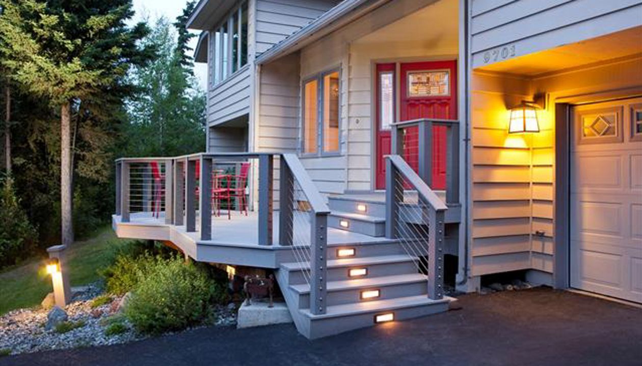 Lighting highlights this Trex and CableRail front porch.