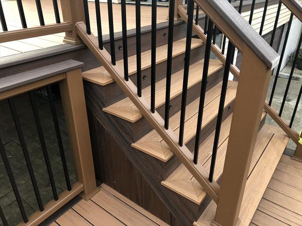Transcend Decking in Tiki Torch with a Lava Rock picture frame, Transcend Tree House Handrail with Lava Rock Coctail Top and Black aluminum balusters,stair lighting, and Lava Rock Fascia.