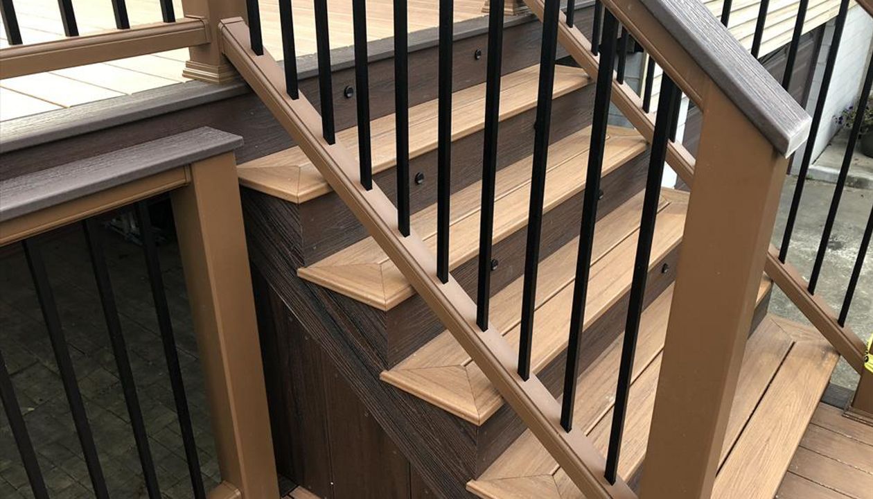 Transcend Decking in Tiki Torch with a Lava Rock picture frame, Transcend Tree House Handrail with Lava Rock Coctail Top and Black aluminum balusters,stair lighting, and Lava Rock Fascia.