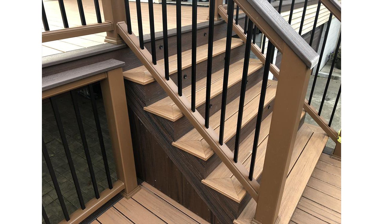 Transcend Decking in Tiki Torch with a Lava Rock picture frame, Transcend Tree House Handrail with Lava Rock Coctail Top and Black aluminum balusters,stair lighting, and Lava Rock Fascia.