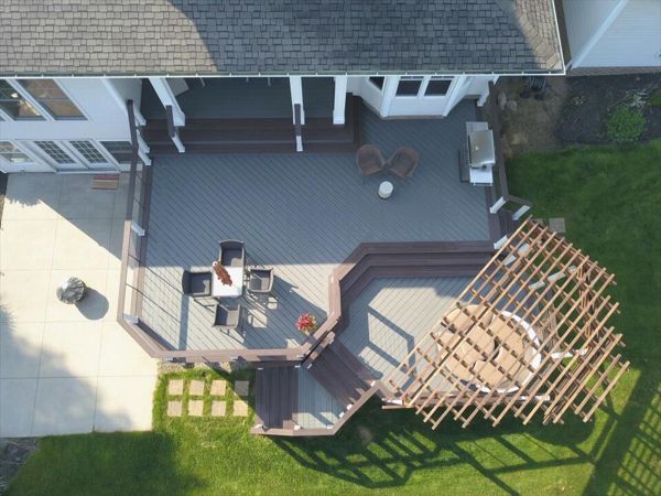 Trex Enhance Clamshell deck featuring Trex Vintage Lantern boarder, fascia, and cocktail rail. Custom Cedar pergola