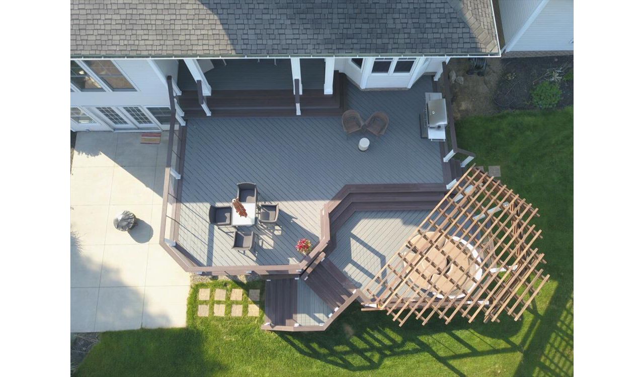 Trex Enhance Clamshell deck featuring Trex Vintage Lantern boarder, fascia, and cocktail rail. Custom Cedar pergola