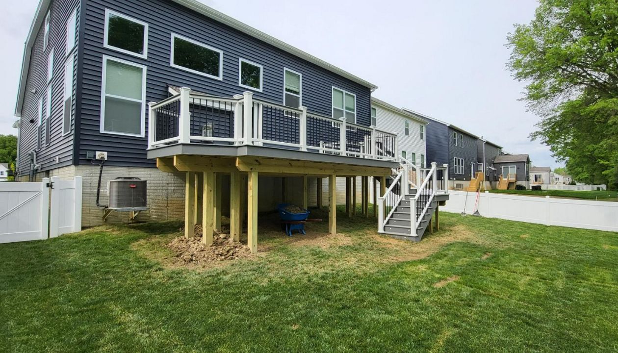 Pebble Grey Deck with Cocktail rail, rise lights in wrap around steps and customary grill bumpout!