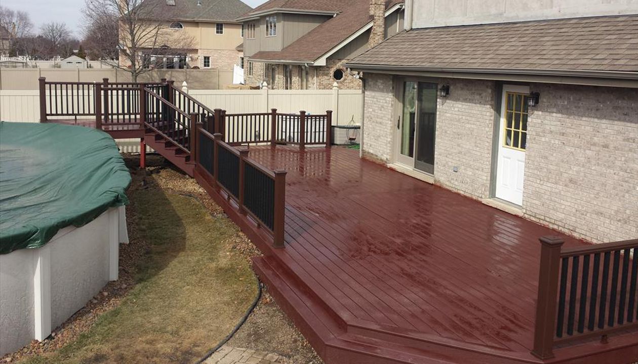 Trex Select decking in Madeira. Trex Transcend railing system in Vintage Lantern with Charcoal Black balusters.