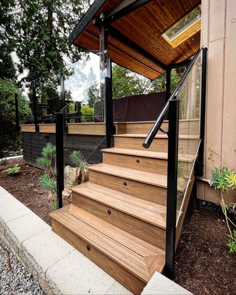 Toasted Sand field, bordering, risers, and fascia, complimented with stained black Cedar skirting. Frameless glass railings, and a lighting package complete the ensemble.