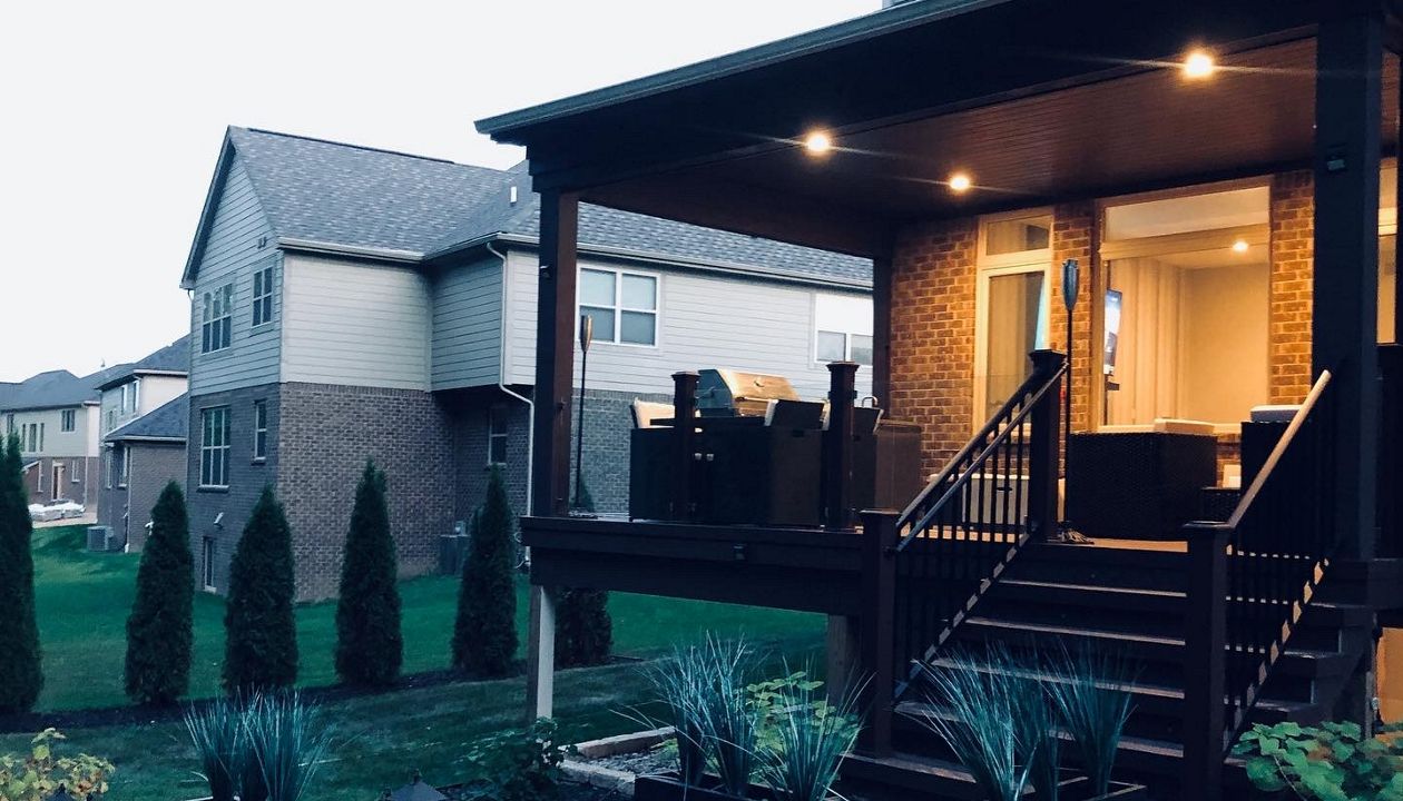 Contemporary Covered TREX SPICED RUM DECK with glass mounted between TREX Transcends post, cap, and skirt