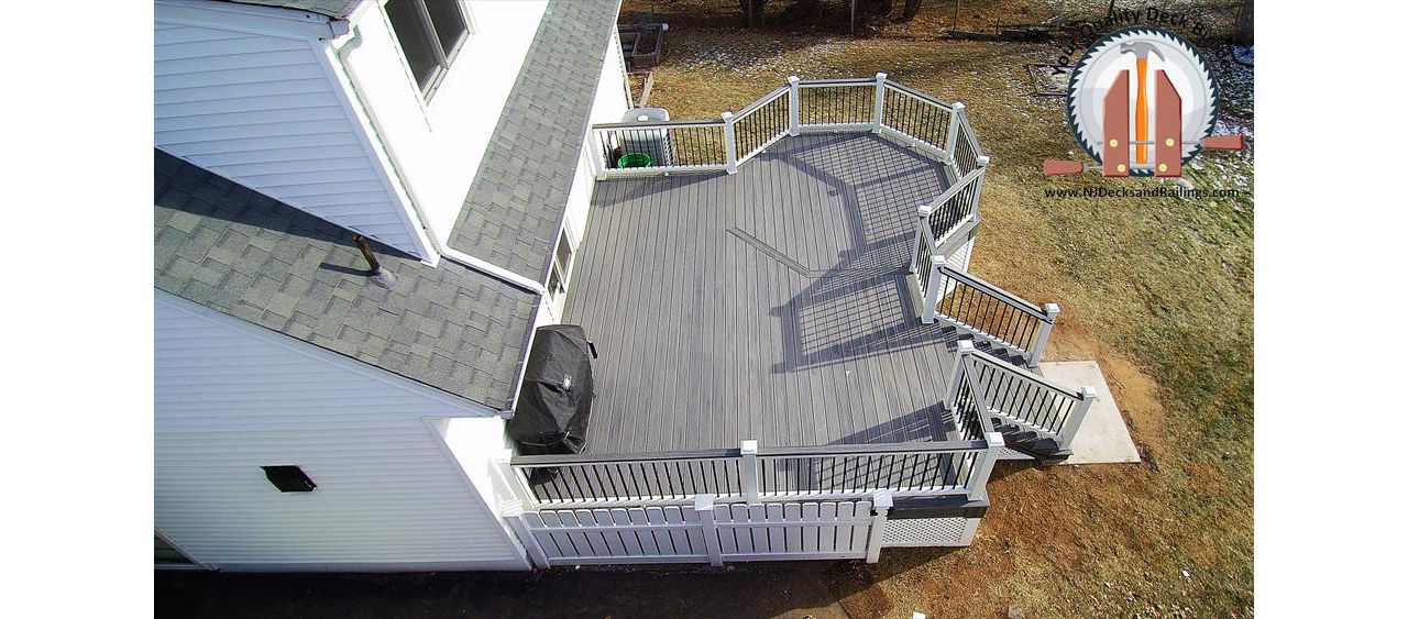 Custom designed deck in Nutley, NJ with an octagon on one corner. This deck is Trex Transcend Island Mist decking with Trex Transcend white railings and black square aluminum balusters. There is also an Island Mist cocktail rail.