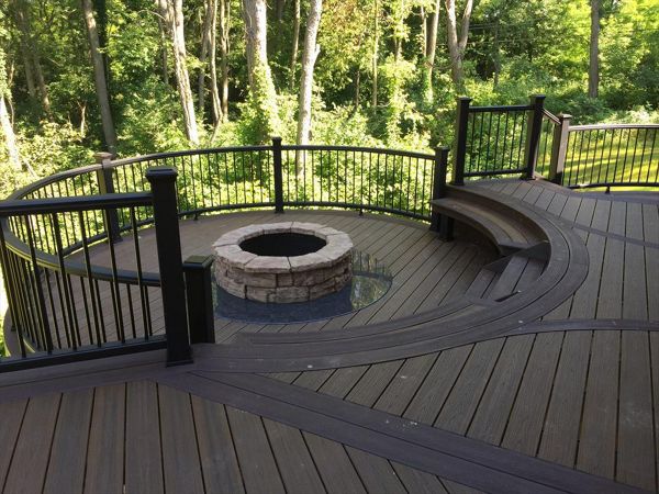 This custom Trex deck has a custom curved seating area along with a custom firepit to keep you warm on those cool summer nights. This deck has Trex transcends havana gold decking and a custom curved vintage lantern rail.