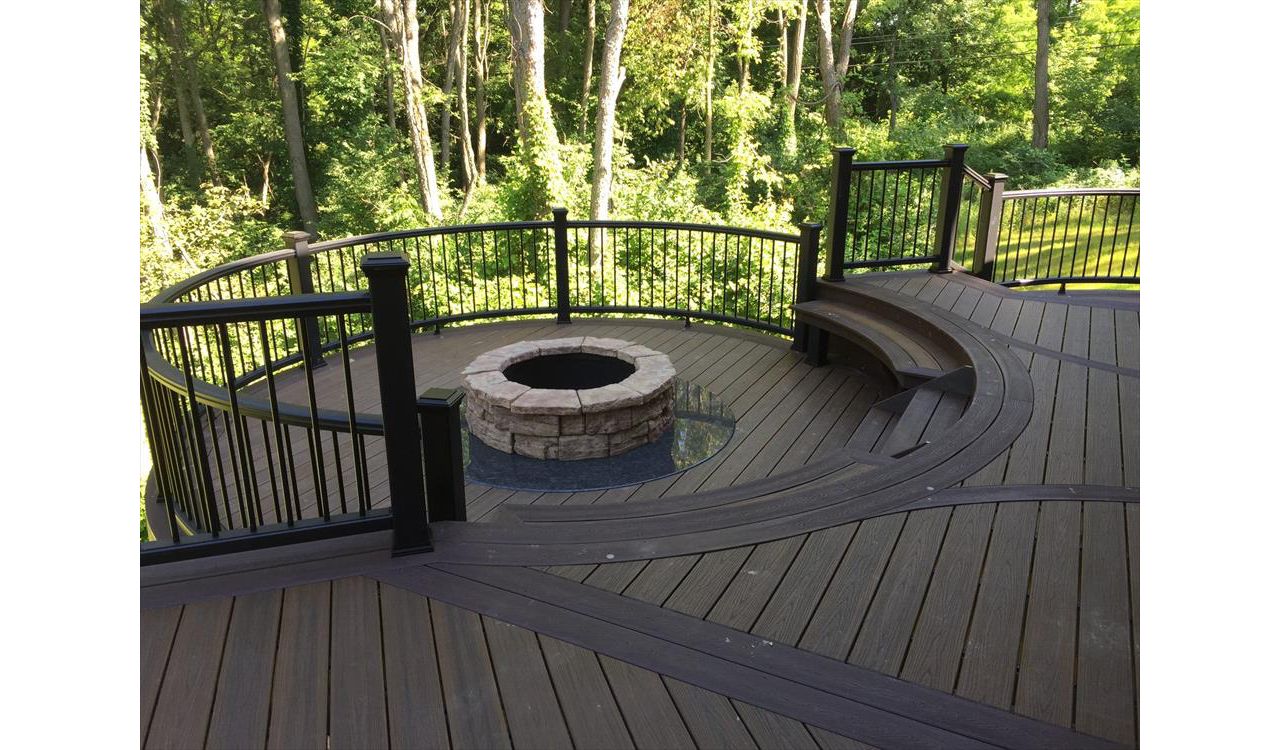 This custom Trex deck has a custom curved seating area along with a custom firepit to keep you warm on those cool summer nights. This deck has Trex transcends havana gold decking and a custom curved vintage lantern rail.
