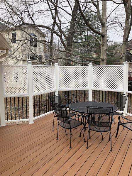 Deck in Trex Transcends Tiki Torch and white Trex Transcends railing with black round aluminum balusters with pyramid finial post caps in Springfield, VA
