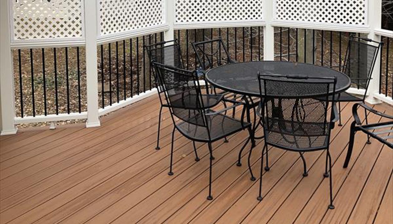 Deck in Trex Transcends Tiki Torch and white Trex Transcends railing with black round aluminum balusters with pyramid finial post caps in Springfield, VA