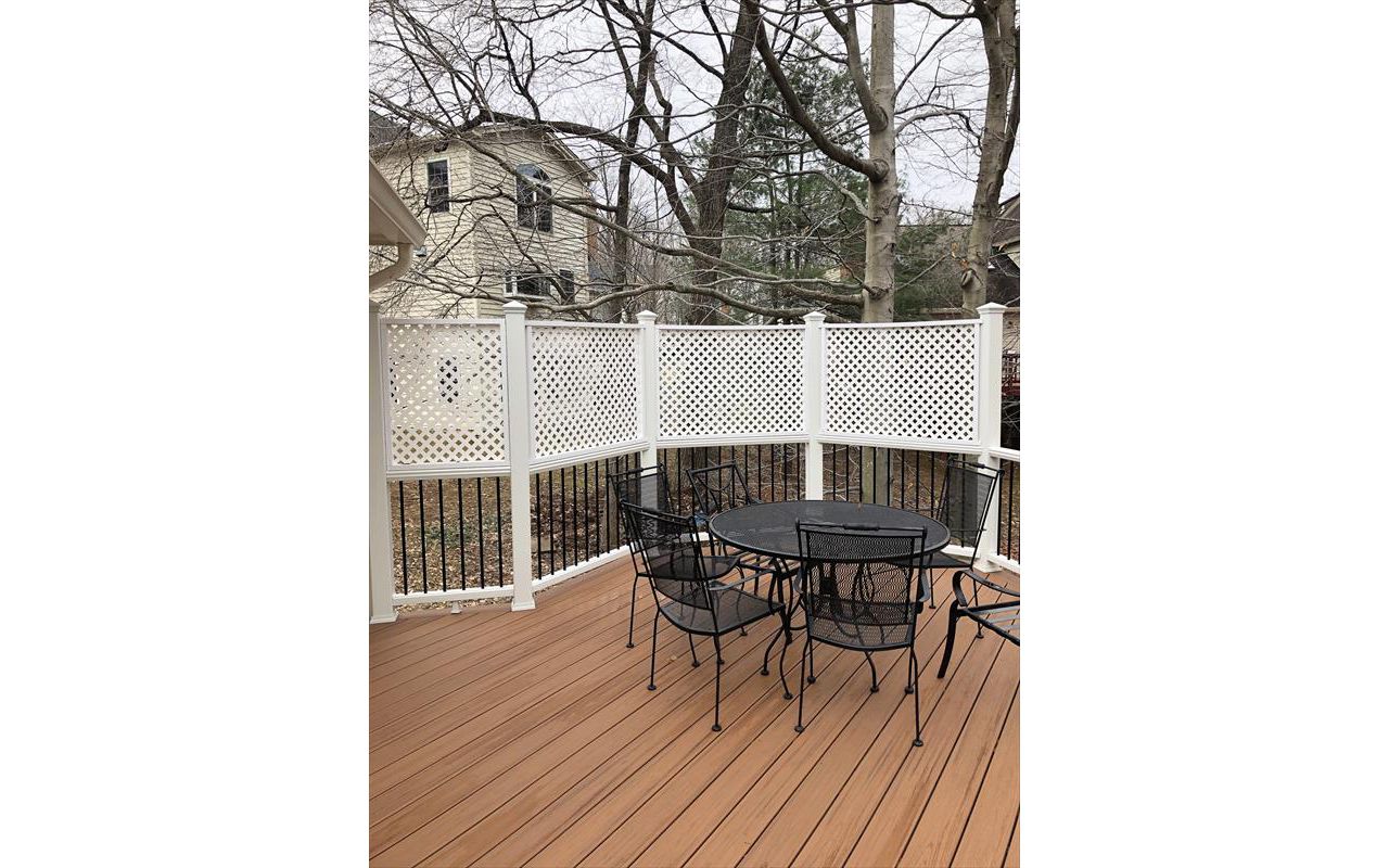 Deck in Trex Transcends Tiki Torch and white Trex Transcends railing with black round aluminum balusters with pyramid finial post caps in Springfield, VA