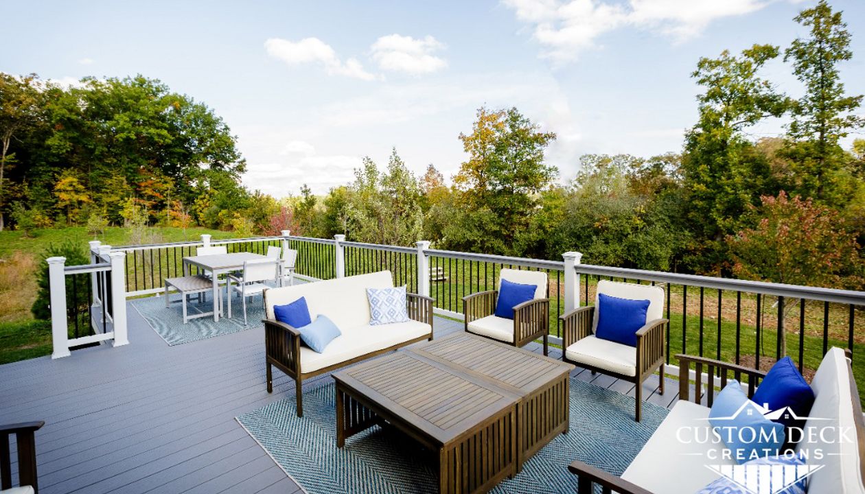 Trex Select Pebble Grey decking built with white Select composite railing, black round aluminum balusters and Pebble Grey drink rail.