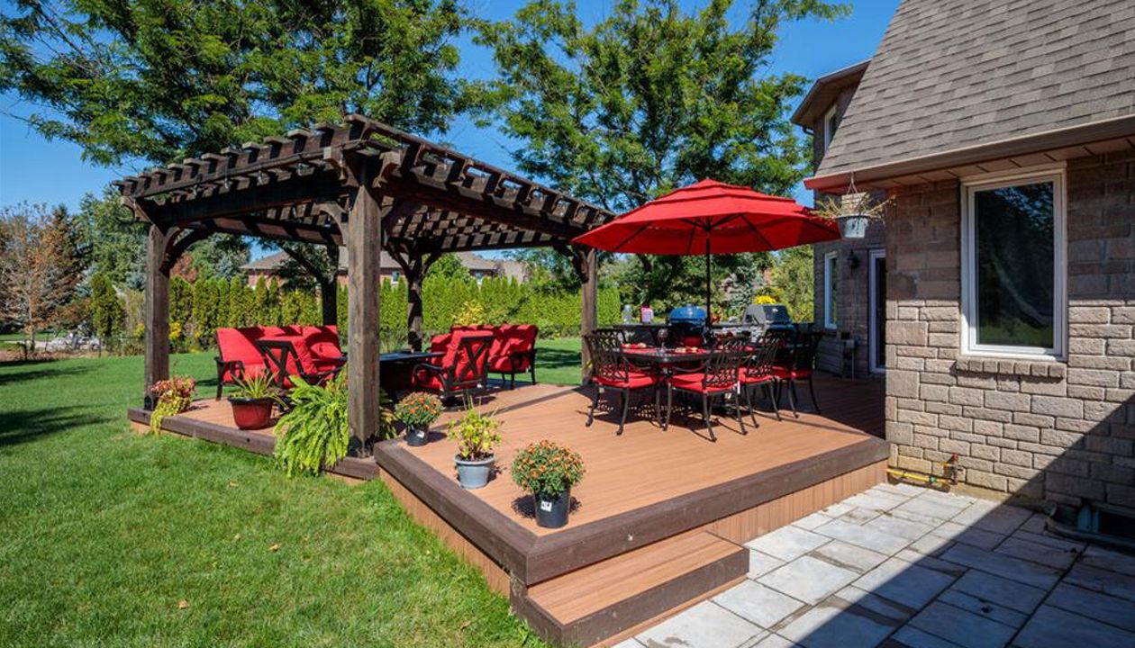 Brown composite decking using Transcend Tiki Torch with Vintage Lantern Trim and custome wood pergola - Orangeville, Caledon, Alliston, Bolton, Schomberg, Nobelton