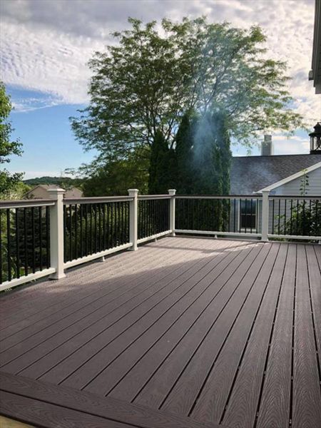 This deck consists of Trex select saddle decking and drink rail. The railing is Trex Transcend with white top bottom rail and round aluminum ballasters.