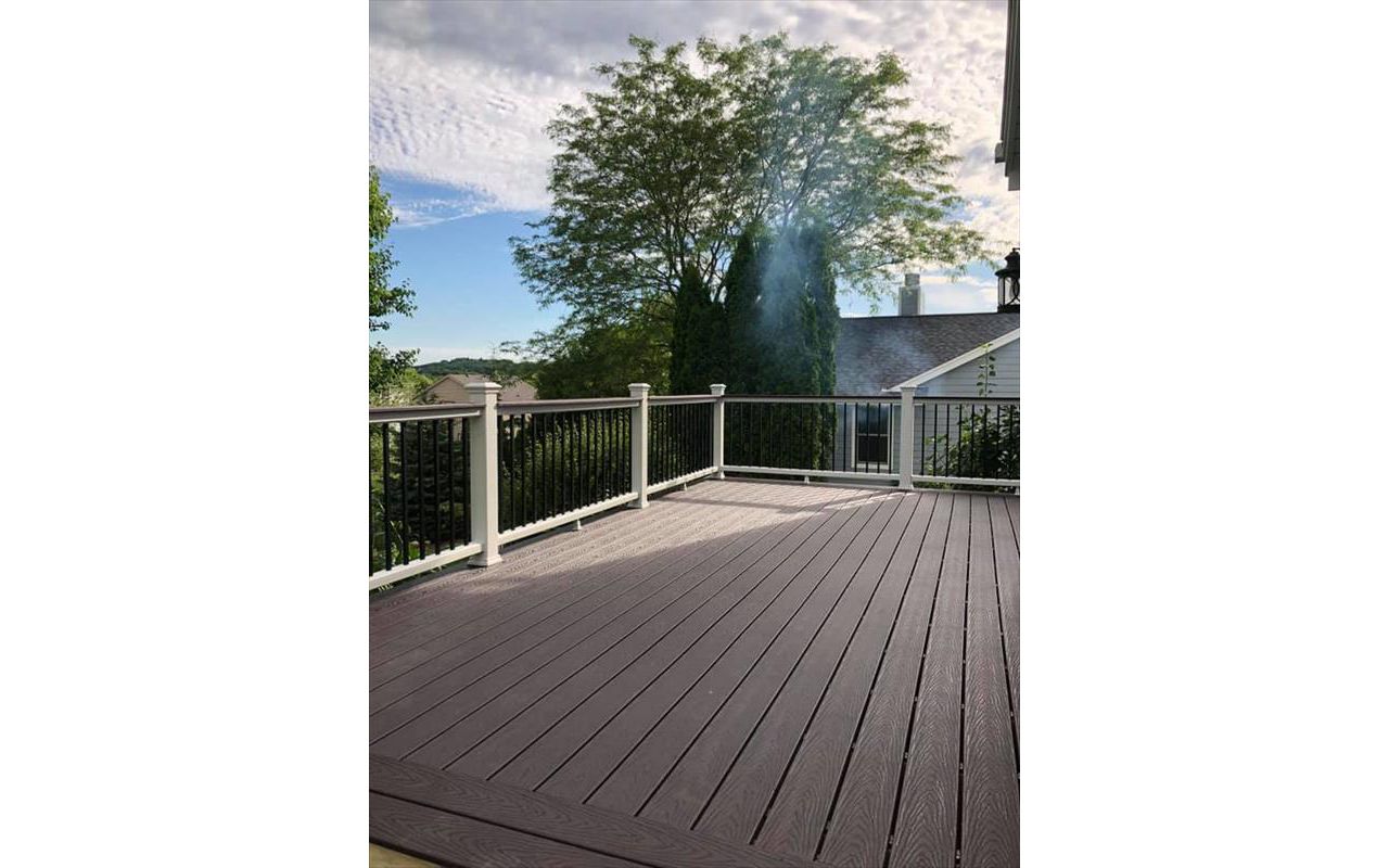 This deck consists of Trex select saddle decking and drink rail. The railing is Trex Transcend with white top bottom rail and round aluminum ballasters.