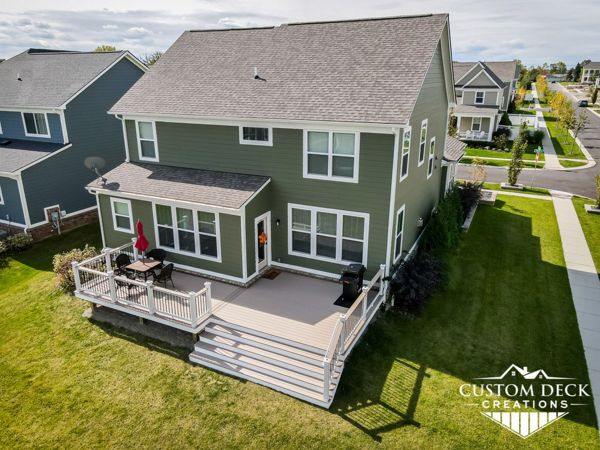 Trex Transcend Rope Swing decking built with white Trex Select composite railing and black round aluminum balusters, topped with matching Rope Swing cocktail board. White Azek PVC fascia.