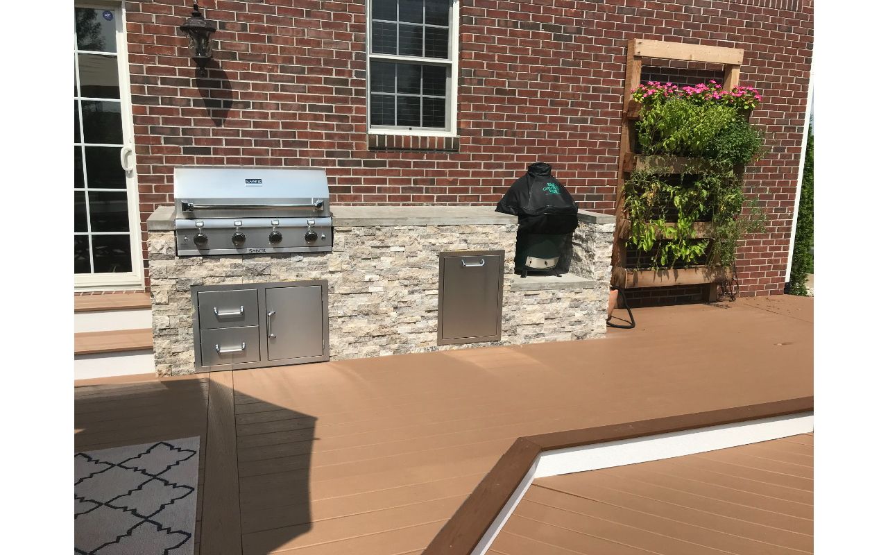 Trex Deck (Beach Dune) with Bullnose Border (Saddle) and Parting Board (Beach Dune). Outdoor Kitchen with Faux stone Façade and Concrete Top.