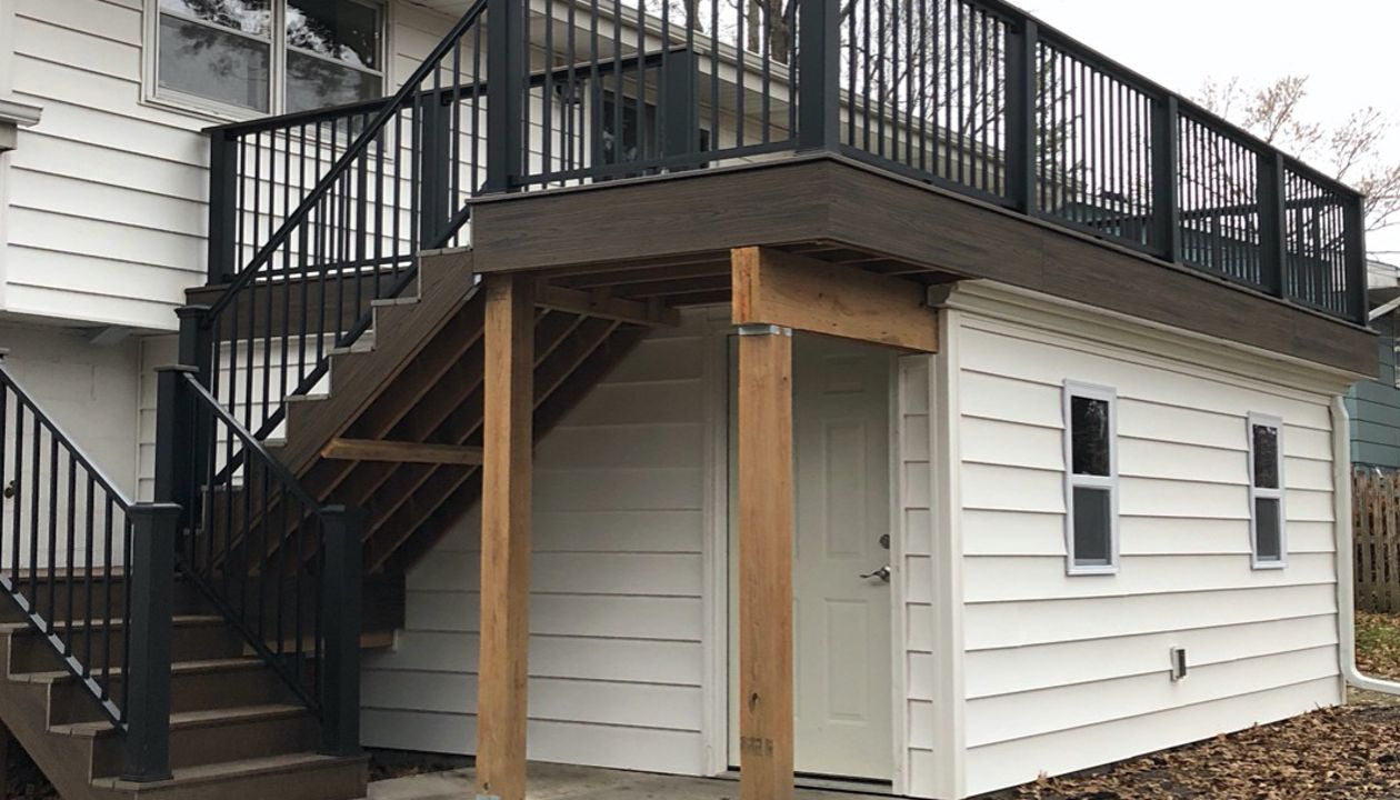 Trex/Transcend/Spiced Rum/Composite Decking with Trex/Signature/Aluminum Railing (black) between Trex Composite Post Sleeves and Trex/Transcend/Spiced Rum/Composite Decking for Cocktail Rail