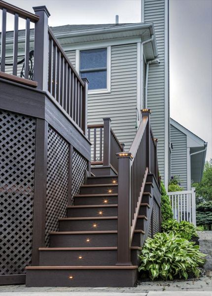 Trex riser lights and pyramid post cap lights elegantly guide you up the stairs to this Clinton, N.J. deck getaway.