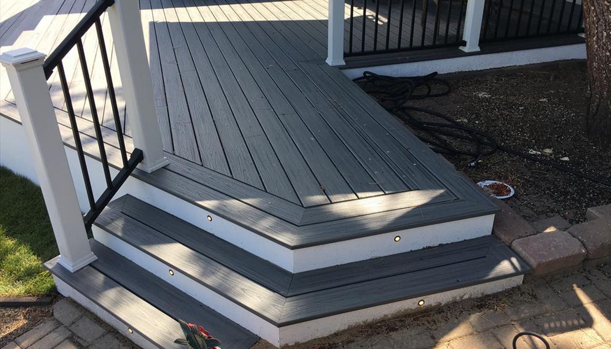 Transcend decking in Island Mist with a double picture frame and stair lighting. Signature Black handrail with white posts and lighted post caps.