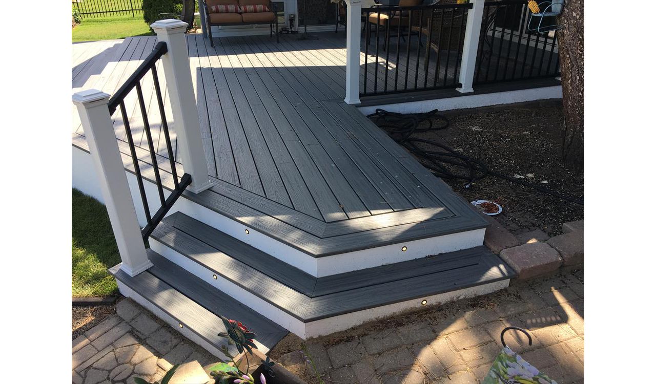 Transcend decking in Island Mist with a double picture frame and stair lighting. Signature Black handrail with white posts and lighted post caps.