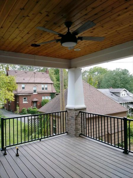Covered porch with Trex Island Mist decking and a Trex Signature black railing.