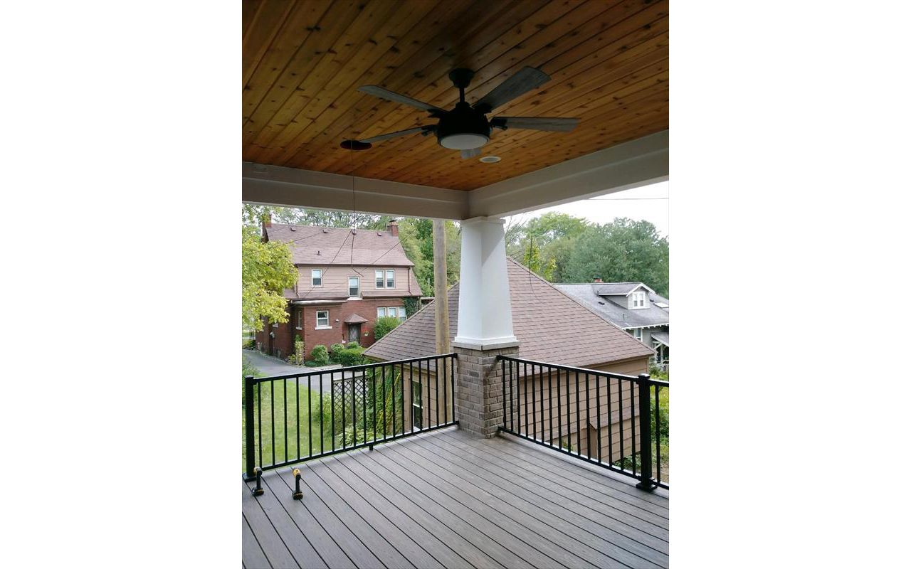 Covered porch with Trex Island Mist decking and a Trex Signature black railing.